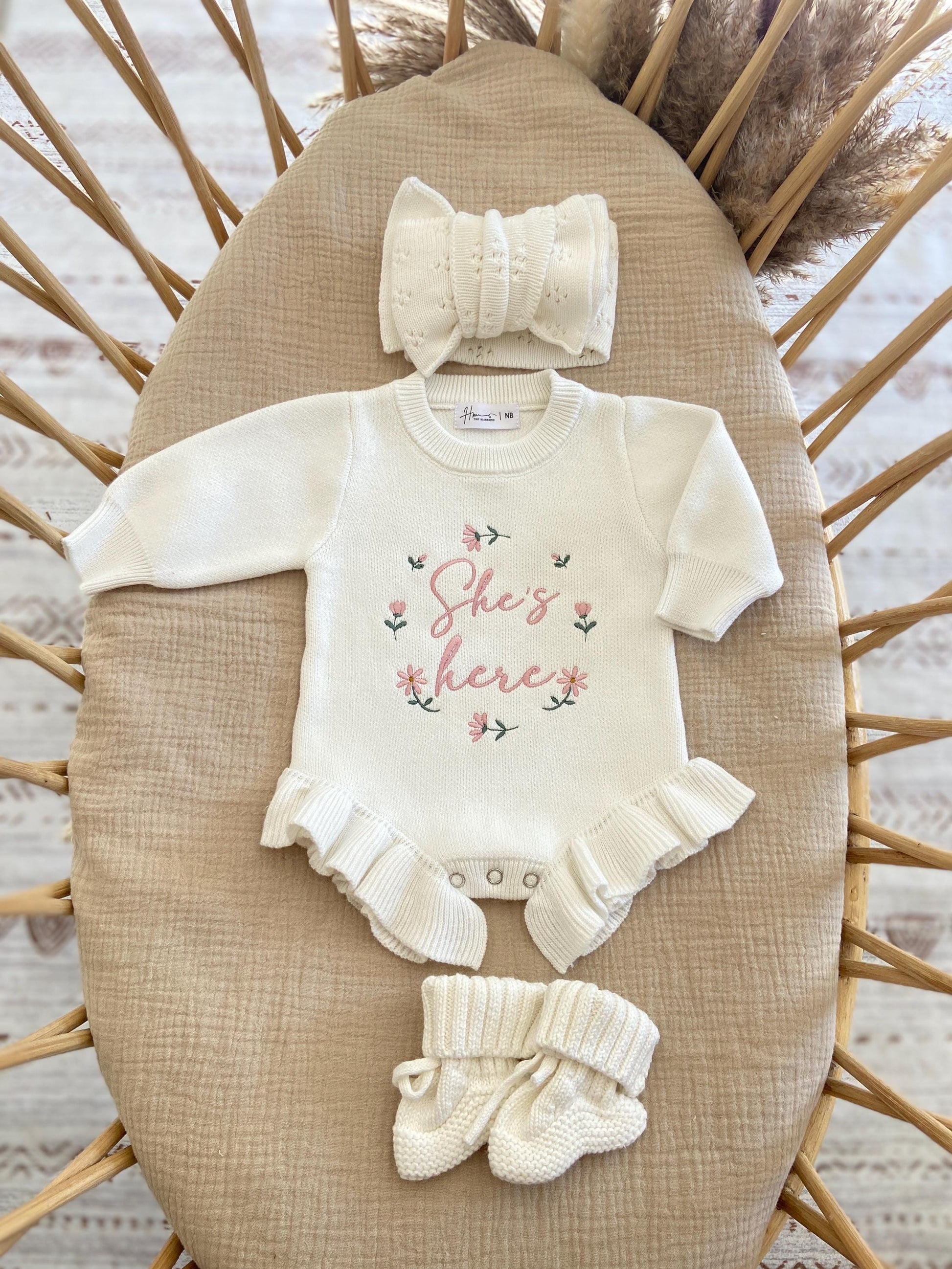 Baby outfit set with 'She's here knit romper hat, and booties.