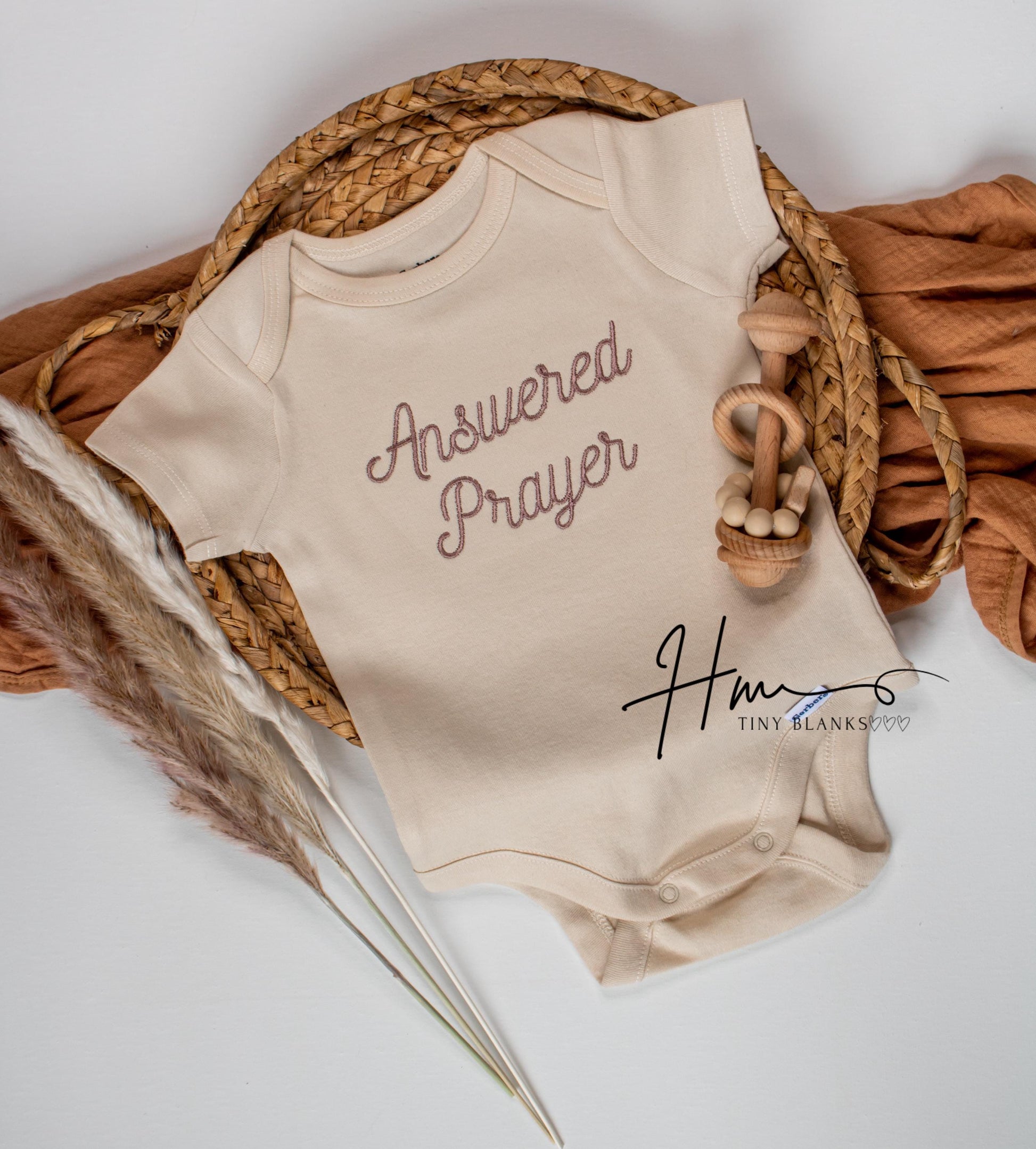 Beige baby onesie with 'Answered Prayer' text 